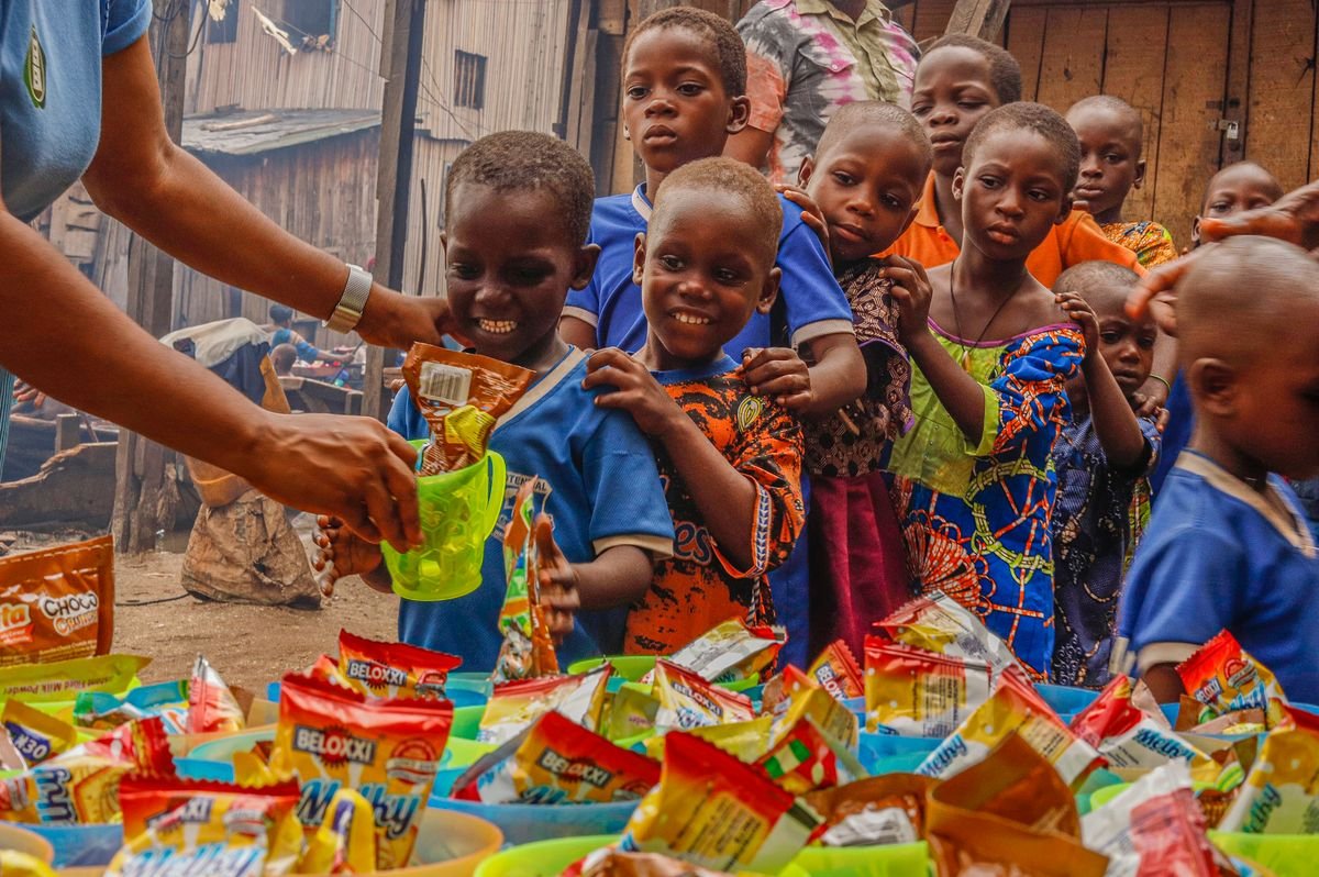 Children receiving food from volunteers